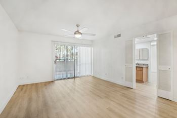 A room with a sliding glass door and a ceiling fan.
